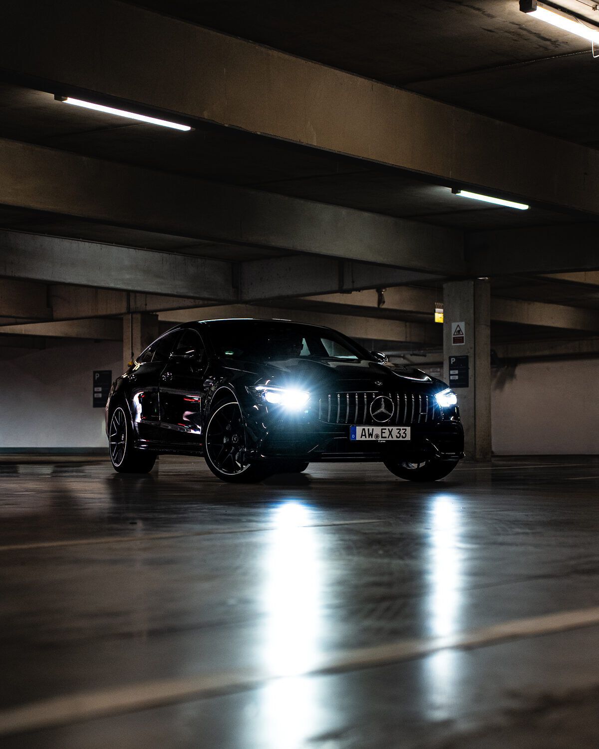 Mercedes-AMG GT 4-Türer in All-Black – Frontansicht mit eingeschaltetem Licht